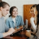 4 adults sitting around a table in the middle of a discussion